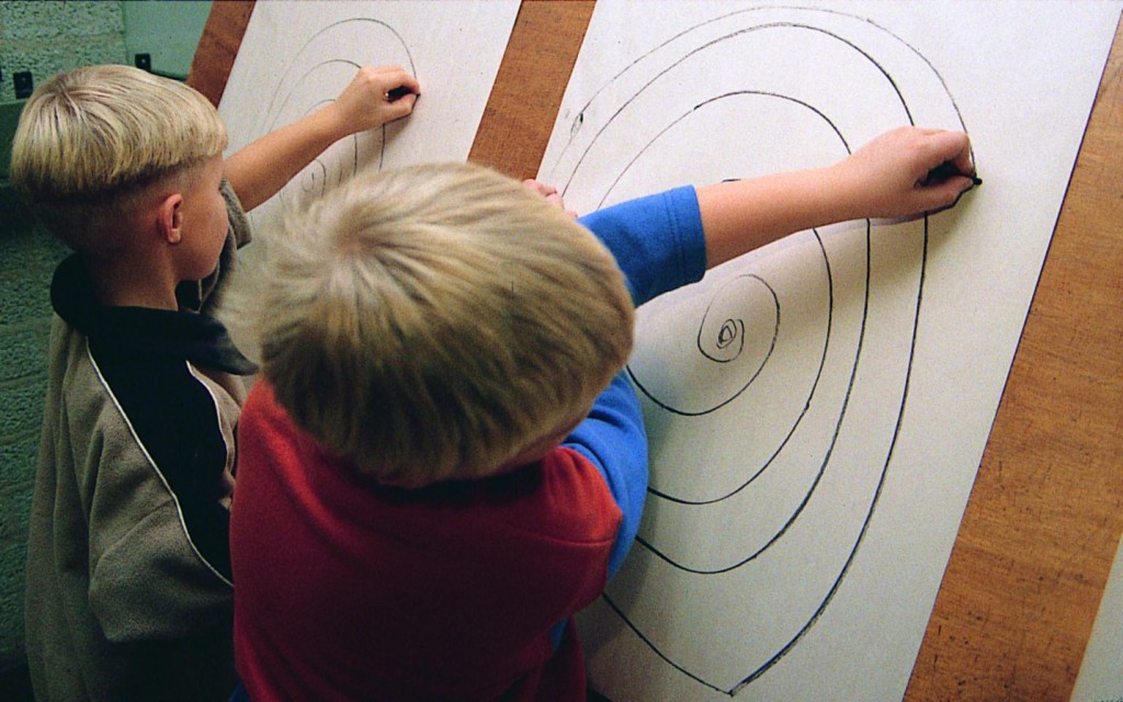 'Jongen uit groep 4 basisschool. De oefening met de spiraal hier met de niet-dominante hand getekend. Jongen uit groep 4 basisschool. Via focus de ruimte naar buiten toe innemen naar expansie en de spiraal ook van buiten naar binnen maken'.