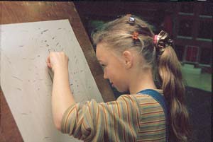 'Meisje van groep 5 op de basisschool tekent onder begeleiding van een Remedial Teacher Corrie Schouten de oefening 'Het Schrift'. Zij tekent met haar niet-dominante hand'.
